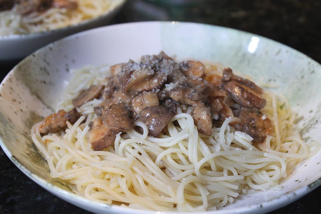 A plate with spaghetti and mushroom sauce
