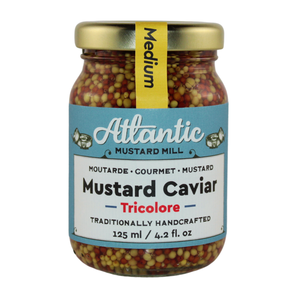 A jar of mustard caviar with three different mustard seeds
